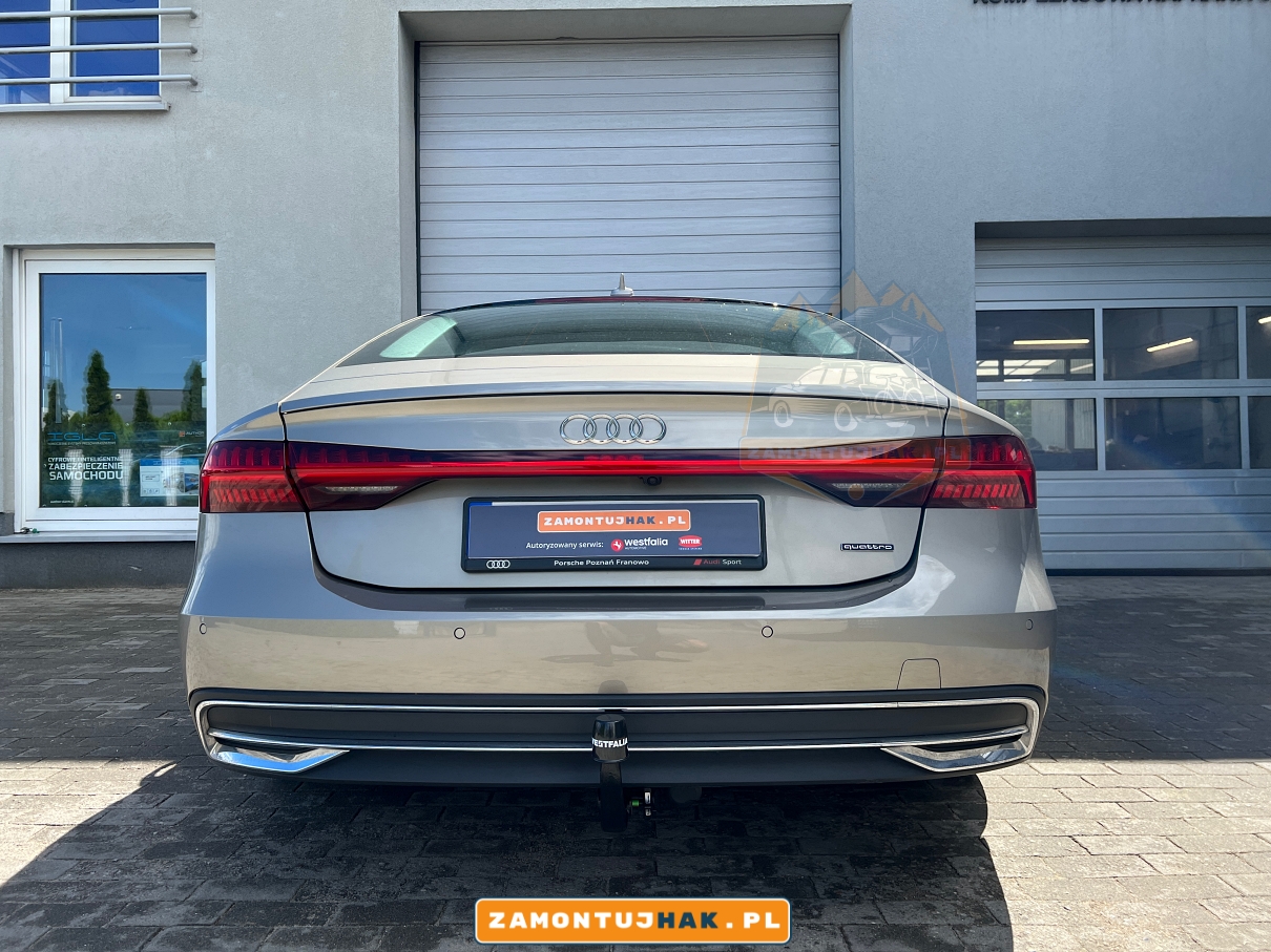 Audi A7 C8 2021 na tle naszego warsztatu montażu haków holowniczych w Poznaniu. Zdemontowana kula haka holowniczego Westfalia A40V o numerach 305603600001